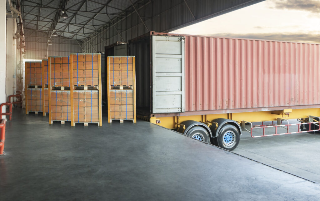 A truck unloads a shipment at an open loading dock.