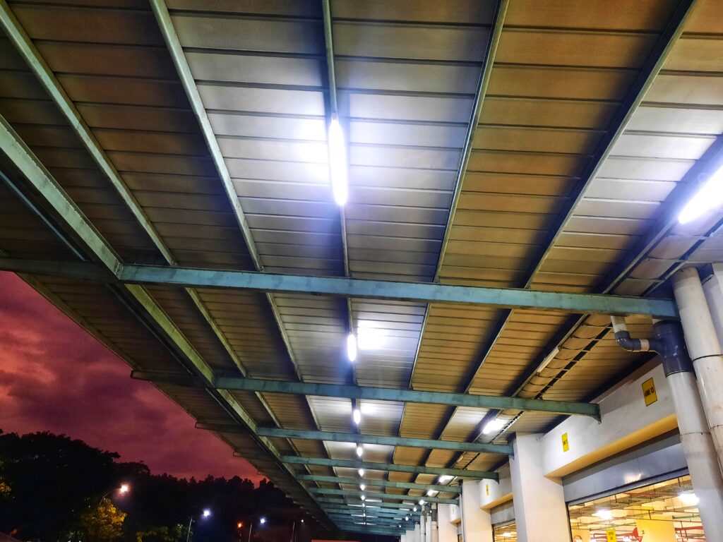 View of the roof of the outside of loading dock doors with bright white lights going down the centre.